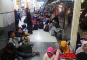Ruang tunggu penuh, calon penumpang lesehan di koridor Stasiun Senen