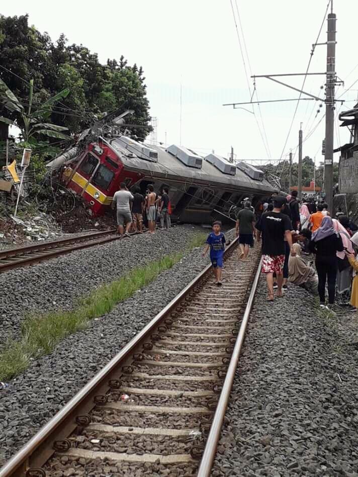 Kereta KRL Bogor-Jatinegara yang terguling sedang dievakuasi