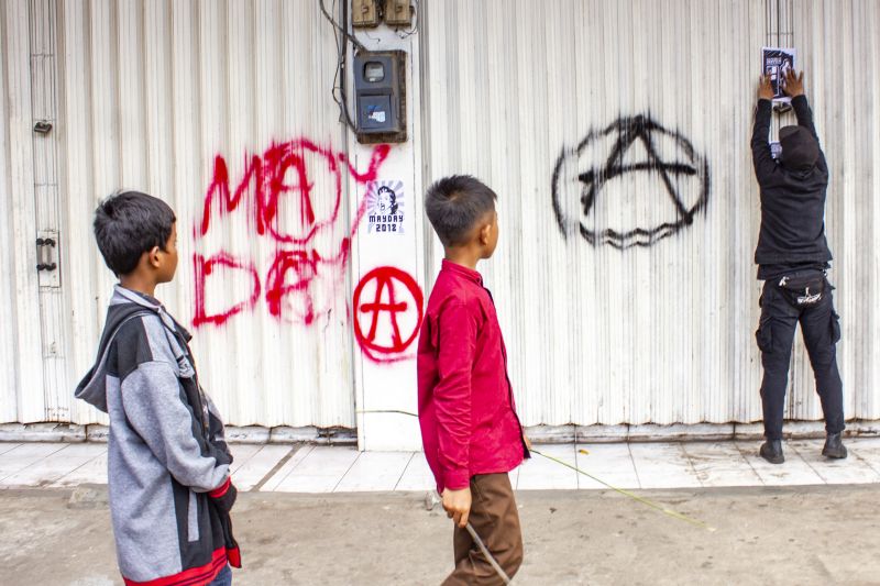 Seorang buruh dari Aliansi Buruh Karawang melakukan aksi vandalisme saat mengikuti aksi Hari Buruh Internasional (May Day) di klawasan By Pass, Karawang, Jawa Barat, Rabu (1/5). /Antara Foto. 