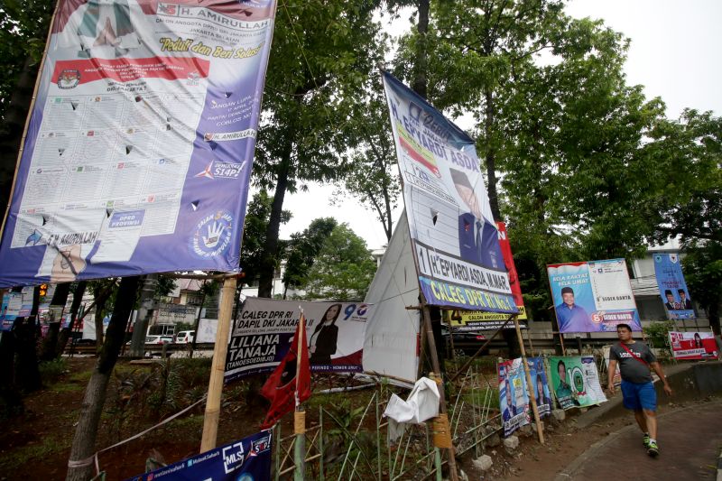Pejalan kaki melintas di depan Alat Peraga Kampanye (APK) Pemilu 2019 di kawasan Kebayoran, Jakarta, Senin (25/3). /Antara Foto. 