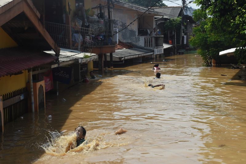 Sejumlah anak bermain air saat banjir melanda permukiman di kawasan Rawajati, Jakarta Selatan, Jum'at (26/4). /Antara Foto. 