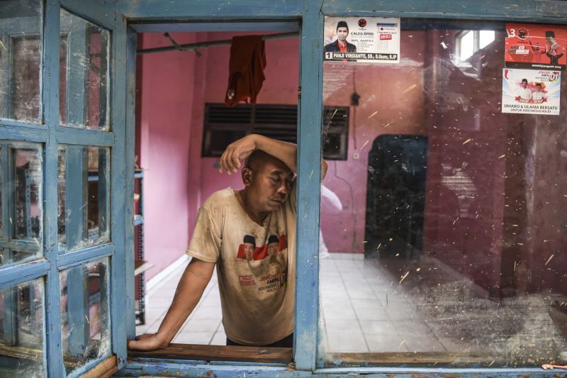 Warga bersandar di jendela usai membersihkan rumahnya dari lumpur pascabanjir di kawasan Kelurahan Rawajati, Jakarta, Senin (29/4). /Antara Foto.