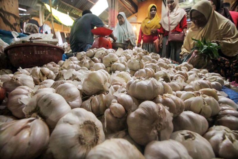 Seorang pedagang melayani pembeli bawang putih di pasar tradisional Inpres Lhokseumawe, Aceh. Senin (3/5). /Antara Foto.