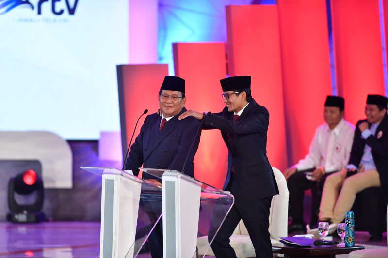 Capres nomor urut 02 Prabowo Subianto (kiri) dipijat pasangan cawapresnya Sandiaga Uno saat jeda Debat Pertama Capres & Cawapres 2019, di Hotel Bidakara, Jakarta, Kamis (17/1). (Antara Foto).