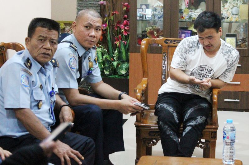 Dua petugas Kantor Imigrasi Pontianak memeriksa WNA asal Tiongkok (kanan) saat penggerebekan sebuah rumah di Komplek Surya Purnama di Pontianak, Kalimantan Barat, Rabu (12/6). /Antara Foto.