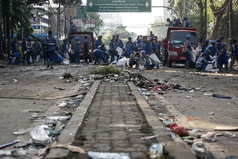 Petugas Sudin Sumber Daya Air membersihkan jalan pascakerusuhan di kawasan Kantor Bawaslu, Jakarta, Kamis (23/5). /Antara Foto.