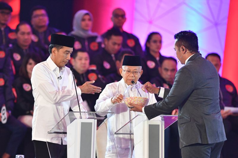 Pasangan capres-cawapres nomor urut 01 Joko Widodo (kiri) dan Ma'ruf Amin mengambil undian pertanyaan saat debat pertama Pilpres 2019, di Hotel Bidakara, Jakarta, Kamis (17/1). (Antara Foto).