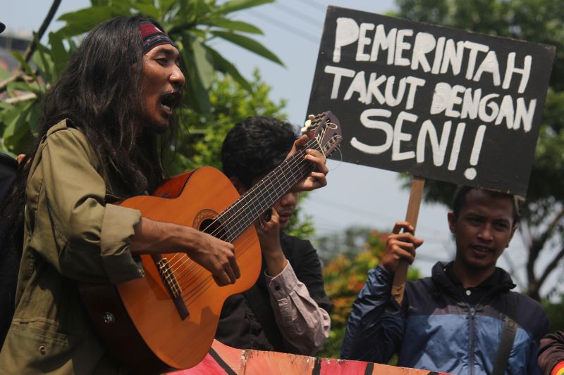 Massa dari jaringan lintas komunitas serta masyarakat umum yang tergabung dalam Suara Merdeka bernyanyi dan memainkan alat musik saat berunjuk rasa di Surabaya, Jawa Timur, Senin (18/2). (Antara Foto).