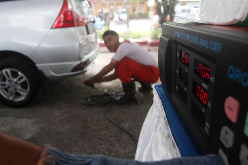Petugas menggunakan alat pengukur gas CO saat melakukan uji emisi gas buangan kendaraan roda empat, di Padang, Sumatera Barat, Rabu (10/4). /Antara Foto.
