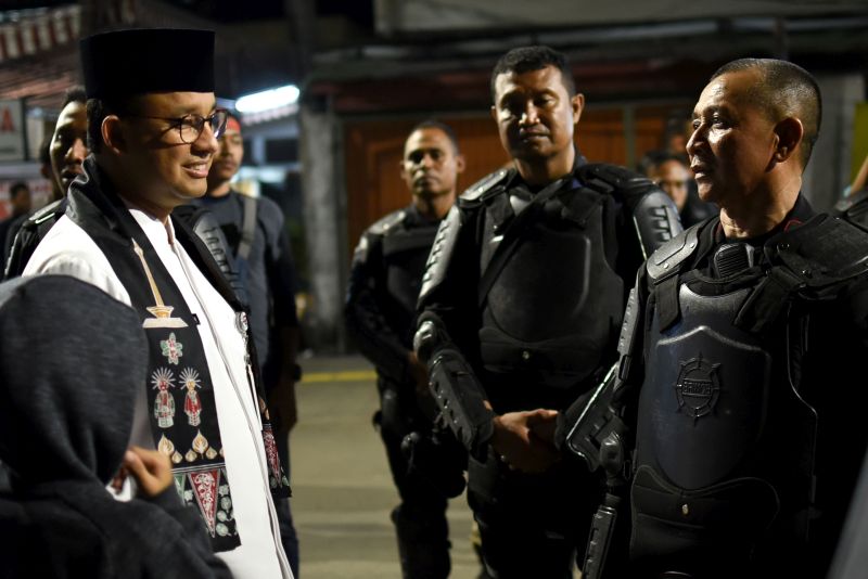 Gubernur DKI Jakarta Anies Baswedan (kiri) berbincang dengan z petugas polisi yang bertugas mengamankan kawasan sekitar Kantor Bawaslu RI di Jalan Wahid Hasyim, Jakarta Pusat, Jumat (24/5) malam. /Antara Foto.
