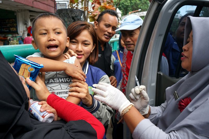 Seorang anak diberikan imunisasi oleh petugas Puskesmas di Pasar Sritanjung, Banyuwangi, Jawa Timur,Sabtu (22/12/2018). (Antara Foto).
