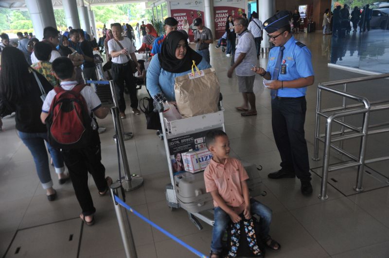 Petugas memeriksa tiket calon penumpang di depan pintu keberangkatan Bandara Sultan Mahmud Badaruddin (SMB) II Palembang, Sumsel, Minggu (9/6). /Antara Foto. 