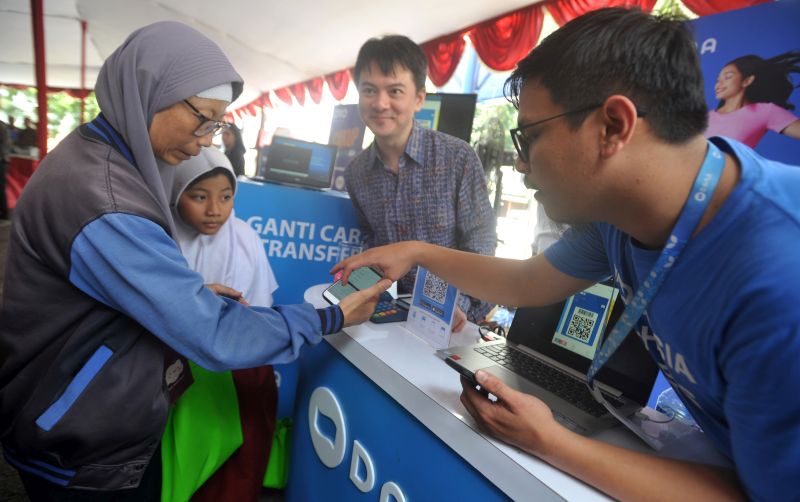 CEO DANA Vincent Iswara (tengah) menyaksikan pengunjung menerima penjelasan mengenai cara pendaftaran Dompet Digital DANA pada peresmian Gerakan UMKM Go Online, di Jakarta, Selasa (26/2). (Antara Foto). 