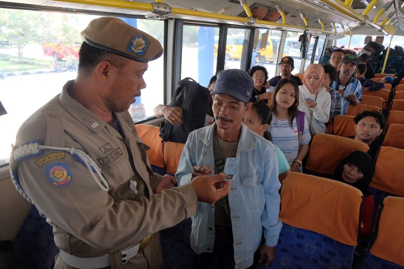 Anggota Satpol PP Kabupaten Badung memeriksa identitas pemudik yang akan balik Lebaran di Terminal Mengwi, Badung, Bali, Minggu (9/6). /Antara Foto.