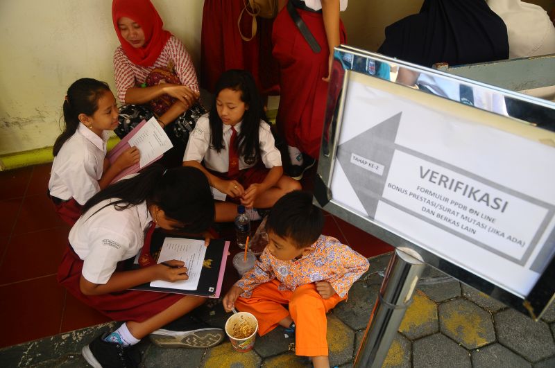Sejumlah siswa dan orang tua murid antre untuk mengikuti seleksi Penerimaan Peserta Didik Baru (PPDB) di SMP 1 Kudus, Jawa Tengah, Rabu (19/6). /Antara Foto. 
