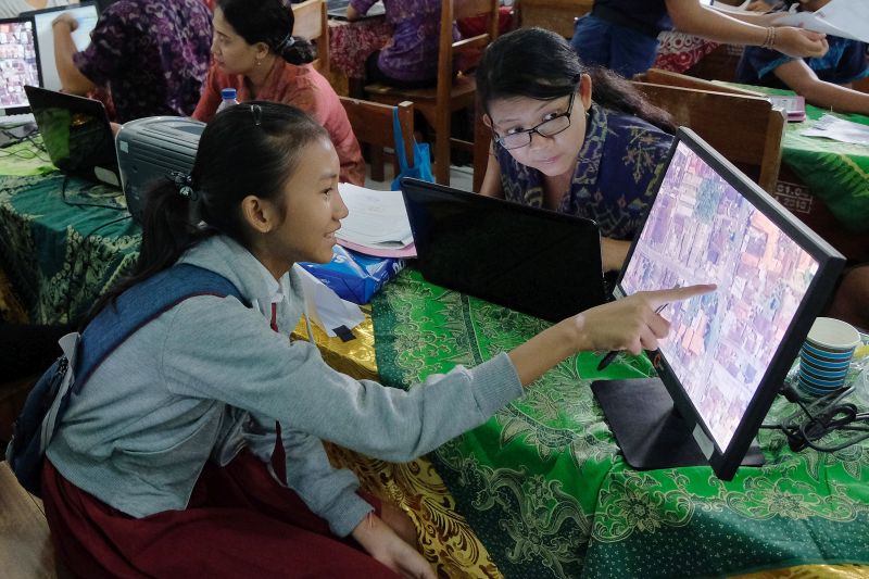 Calon peserta didik baru menunjukkan lokasi tempat tinggalnya di peta daring saat proses verifikasi berkas dan pengambilan kode akun dalam pendaftaran Penerimaan Peserta Didik Baru (PPDB) untuk jalur zonasi di SMPN 10 Denpasar, Bali, Selasa (18/6). /Antara Foto.