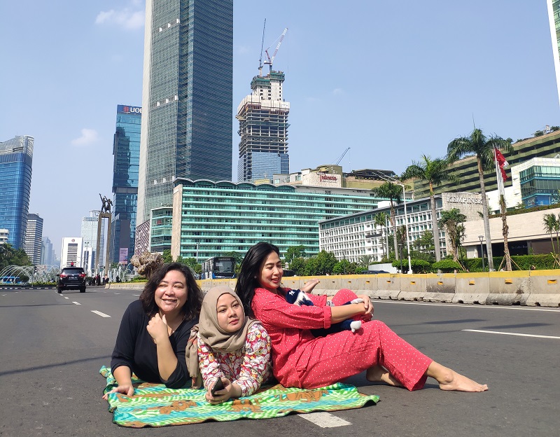 Tiga gadis warga DKI Jakarta berfoto di Jalan Sudirman Jakarta, Kamis (6/6). Alinea.id/Annisa Rahmawati