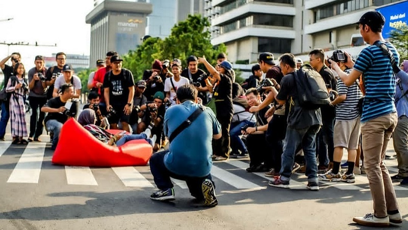 Fotografer tengah mengabadikan seorang model yang berpose di jalan protokol Jakarta. Alinea.id/Annisa Rahmawati