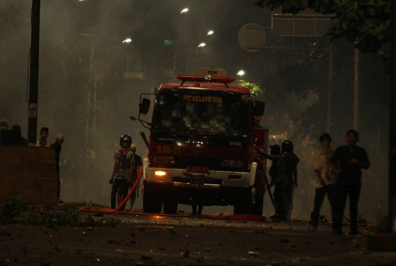 Massa aksi melakukan pembajakan sebuah mobil pemadam kebakaran saat terjadinya kericuhan di atas jalan layang Slipi Jaya, Jakarta, Rabu (22/5)./ Antara Foto