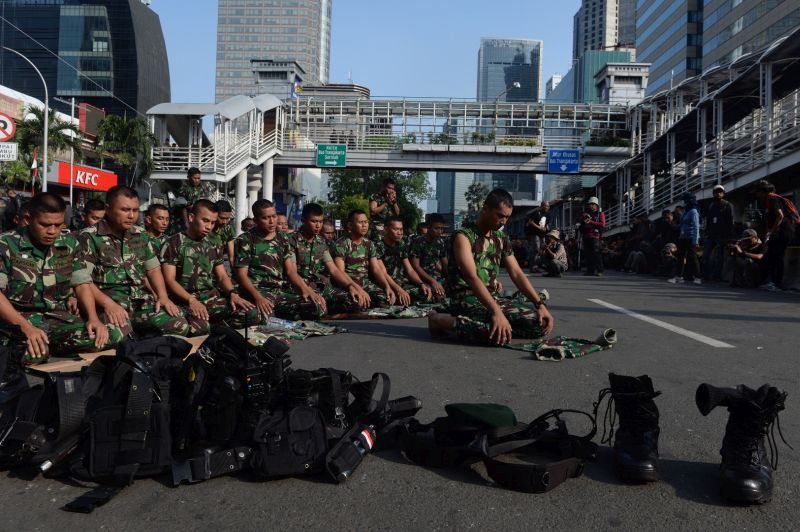Sejumlah personel TNI AD menunaikan Sholat Zhuhur ketika berjaga di depan gedung Bawaslu, Jalan MH. Thamrin, Jakarta, Rabu (22/5)./ Antara Foto