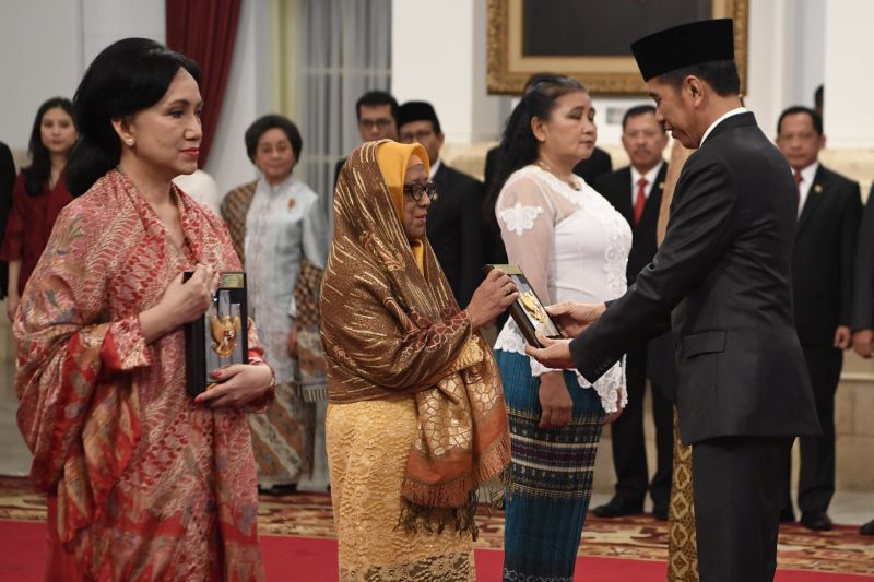 Presiden Joko Widodo (kanan) menyerahkan plakat anugerah gelar pahlawan nasional kepada ahli waris Prof KH Abdul Kahar Muzakkir di Istana Negara, Jakarta, Jumat (8/11). /Antara Foto.
