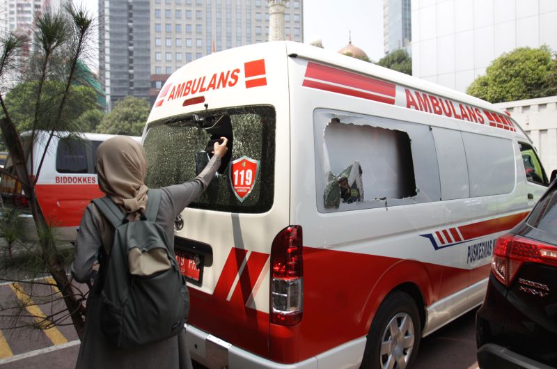 Wartawan mengambil gambar mobil ambulans milik Pemprov DKI Jakarta yang ditahan di Halaman Polda Metro Jaya, Jakarta, Kamis (26/9). /Antara Foto. 