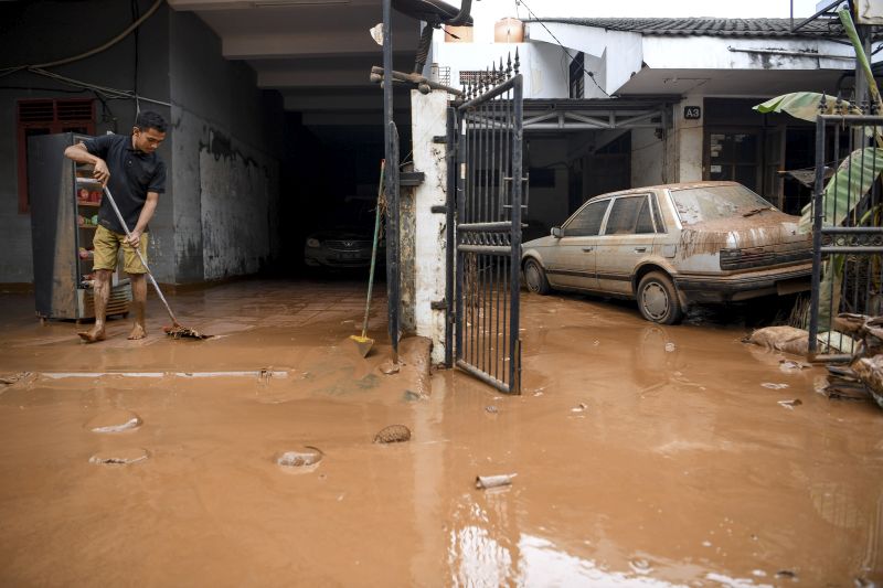 Warga membersihkan rumahnhya pascabanjir yang melanda Kompleks IKPN Bintaro, Pesanggrahan, Jakarta, Jumat (3/1/2019). Foto Antara/Hafidz Mubarak A