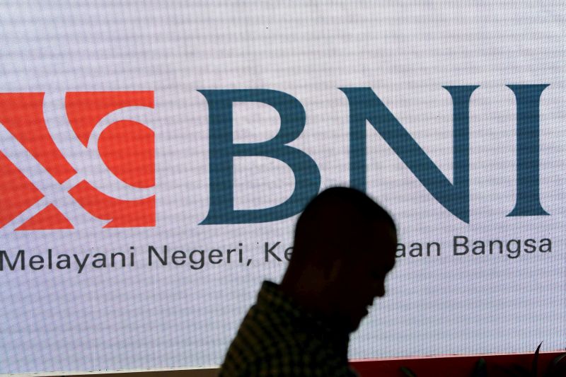 Warga melintasi layar digital promosi Bank Negara Indonesia (BNI) di Jakarta, Rabu (23/10). /Antara Foto.
