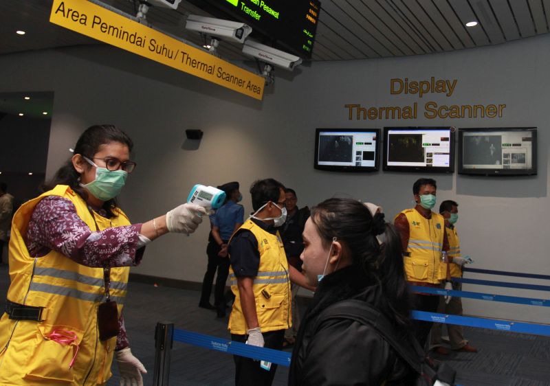 Petugas Kantor Kesehatan Pelabuhan (KKP) Kelas 1 Bandara Soetta melakukan pemeriksaan suhu tubuh penumpang pesawat yang tiba di Terminal 3 Bandara Soekarno Hatta, Tangerang, Banten, Selasa (3/3/2020). Foto Antara/Muhammad Iqbal.