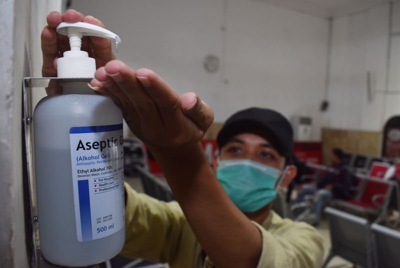Calon penumpang Kereta Api (KA) membersihkan tangannya menggunakan hand sanitizer yang tersedia di Stasiun KA Madiun, Jawa Timur, Selasa (3/3/2020). Foto Antara/Siswowidodo.