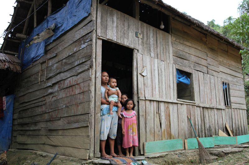 Darmayanti bersama tiga orang anak yang belum pernah mendapatkan bantuan apapun dari Dana Desa berada di pintu rumahnya di Desa Andobeu Jaya, Kecamatan Anggomoare, Kabupaten Konawe, Sulawesi Tenggara, Kamis (7/11). /Antara Foto. 
