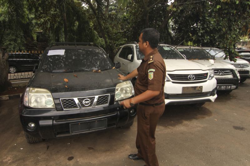 Petugas Kejaksaan menunjukkan aset mobil First Travel Nissan X-Trail warna hitam yang terparkir di Halaman Kejaksaan Negeri Depok, Jawa Barat, Kamis (21/11). /Antara Foto. 