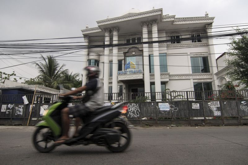 Warga melintas di depan Kantor First Travel Building atas nama Andika di jalan Radar Auri, Depok, Jawa Barat, Rabu (20/11). /Antara Foto.