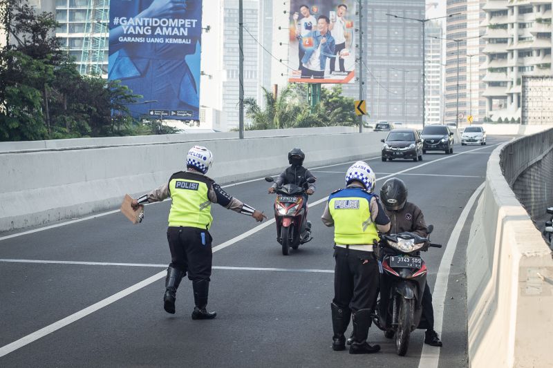 Polisi Lalu Lintas menilang pengendara sepeda motor yang melintas di Jalan Layang Non Tol Kampung Melayu-Tanah Abang, Karet Tengsin, Jakarta, Senin (12/8). /Antara Foto.