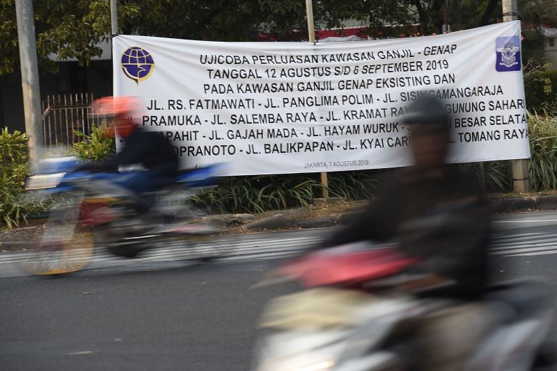 Pengendara sepeda motor melintasi spanduk sosialisasi perluasan aturan ganjil genap di Jalan Veteran, Jakarta Pusat, Senin (12/8). /Antara Foto.