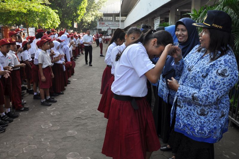 Sejumlah siswa menyalami guru mereka seusai mengikuti upacara di Sekolah Dasar Negeri 060813 Medan, Sumatera Utara, Senin (25/11/2019). Foto Antara/Septianda Perdana.