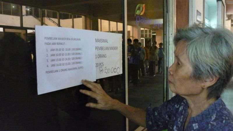 Salah seorang warga membaca imbauan tentang layanan penjualan masker oleh PD Pasar Jaya di Pasar Pramuka, Matraman, Selasa (10/3/2020). Alinea.id/Robertus Rony Setiawan..