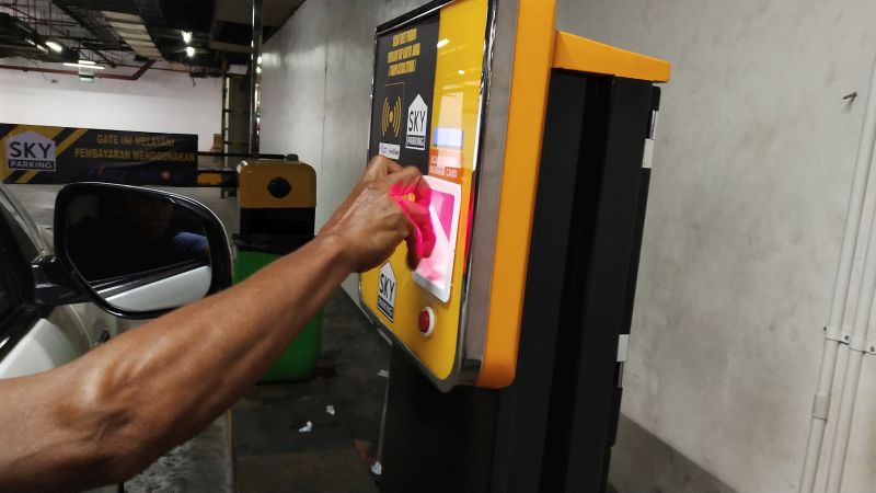 Pengunjung menempelkan dompet elektronik OVO ke mesin pembayaran parkir. Alinea.id/Soraya Novika.