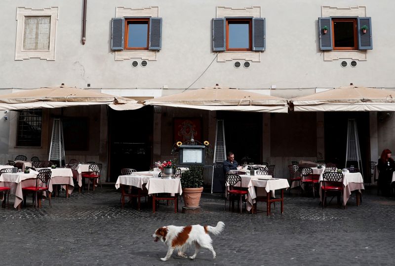 Seekor anjing lewat di depan restoran yang nyaris kosong di wilayah Trastevere, setelah dikeluarkannya dekrit yang memerintahkan penutupan seluruh Italia, sebuah tindakan keras yang belum pernah terjadi sebagai upaya pencegahan penyebaran virus COVID-19, di Roma, Italia, Selasa (10/3/2020). Foto Antara/Reuters/Guglielmo Mangiapane.