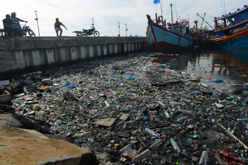 Kapal nelayan bersandar dekat tumpukan sampah botol plastik bekas bercampur minyak solar di Pelabuhan Perikanan Samudera, Lampulo, Banda Aceh, Aceh Senin (15/7). /Antara Foto. 