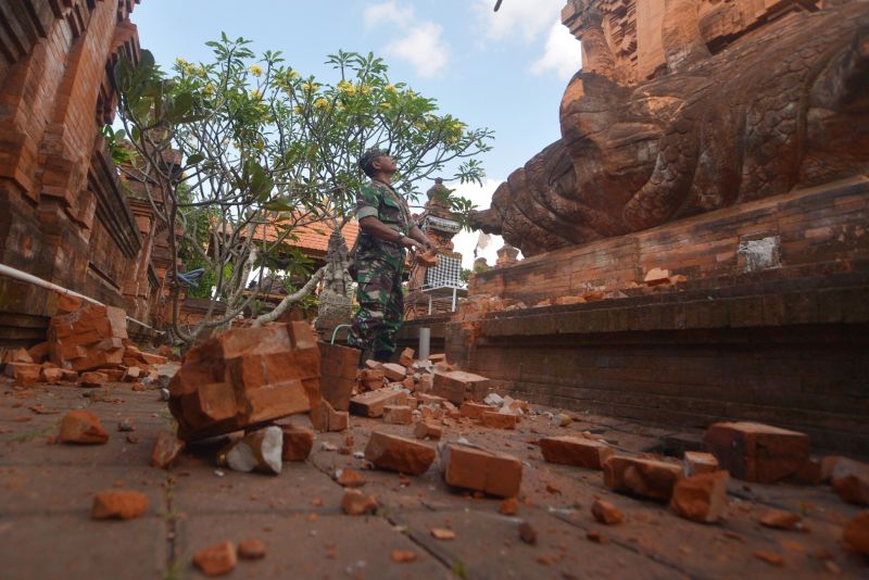 Prajurit TNI memantau kerusakan pada bagian candi yang runtuh akibat gempa di Pura Lokanatha, Denpasar, Bali, Selasa (16/7). /Antara Foto.