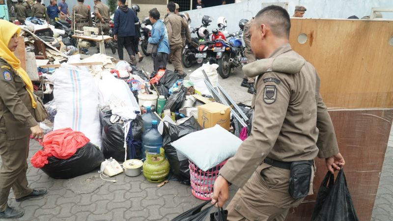 Petugas Satpol PP membantu warga mengamankan barang-barang, Kamis (12/12/2019). Alinea.id/Huyogo Simbolon.