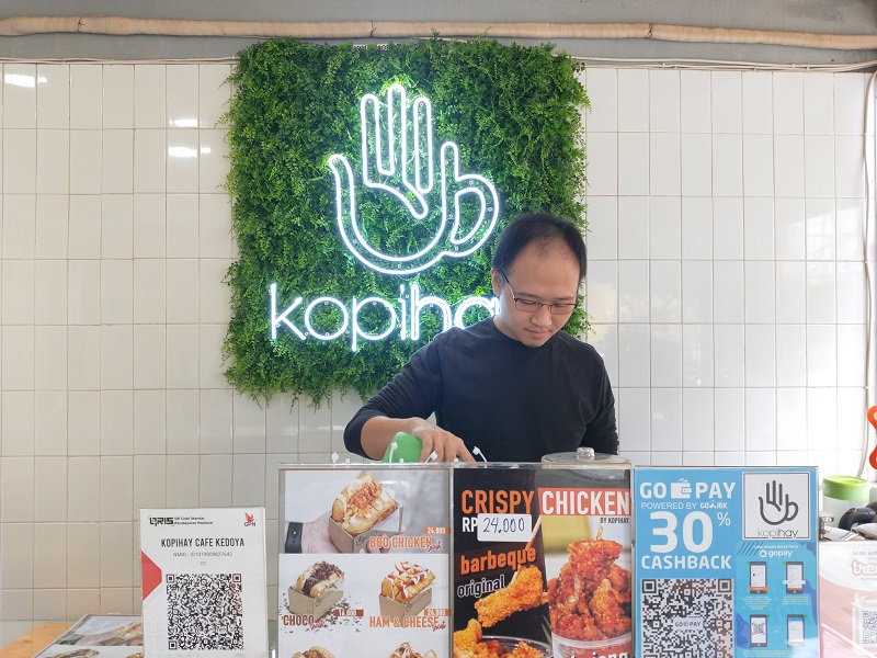 Ricky Wijaya (30 tahun) pemilik kedai Kopihay di bilangan Jakarta Barat mengaku cukup diuntungkan dengan adanya diskon dan cashback yang diberikan perusahaan dompet digital untuk kedainya, Kamis (12/3). Alinea.id/Fajar Yusuf Rasdianto.