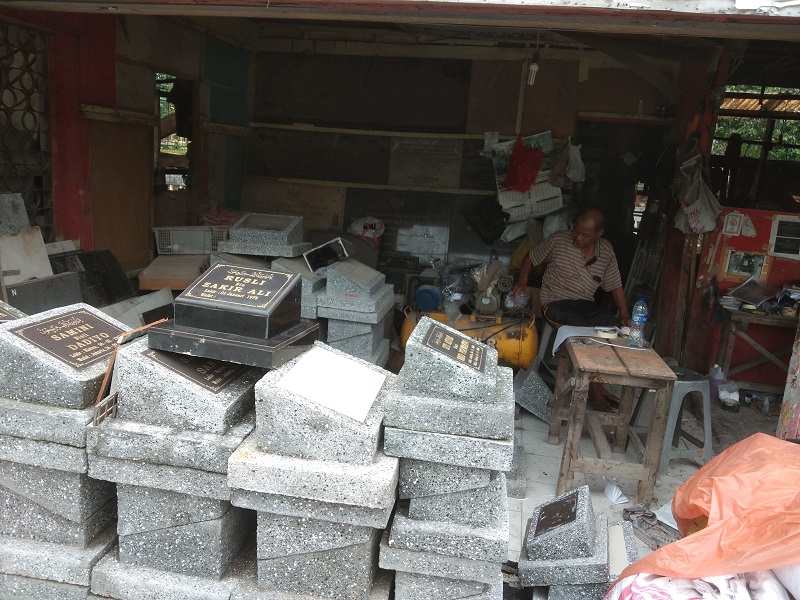 Pemilik Indah Prasasti H.M. Djuanda (60) sedang menunggu pembeli batu nisan dan prasasti di kiosnya, Kalibata, Jakarta Selatan, Selasa (25/2). Alinea.id/Syah Deva Ammurabi