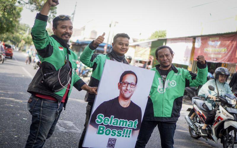 Pengemudi ojek online Gojek membawa poster ucapan selamat kepada Pendiri dan CEO Gojek Nadiem Makarim di Solo, Jawa Tengah, Rabu (23/10). /Antara Foto