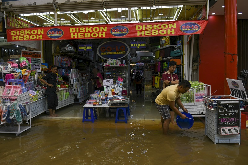 Pekerja membuang air yang masuk ke dalam toko saat banjir menggenangi kawasan Pasar Baru di Jakarta, Kamis (2/1). Berdasarkan data Badan Nasional Penanggulangan Bencana (BNPB) per 2 Januari 2020, terdapat 63 titik banjir di wilayah DKI Jakarta dan secara keseluruhan terdapat 169 titik banjir untuk Jabodetabek dan Banten. / Antara Foto