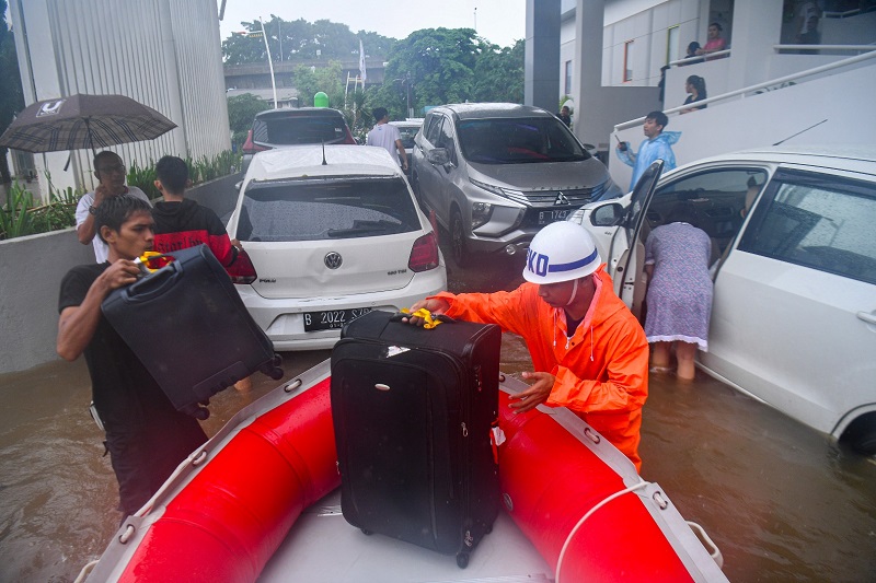 Petugas keamanan mengevakuasi tamu hotel saat banjir menggenangi Jalan Kemang Raya, Jakarta Selatan, Rabu (1/1). Hujan deras yang mengguyur DKI Jakarta membuat sejumlah wilayah di Ibu Kota terendam banjir. / Antara Foto