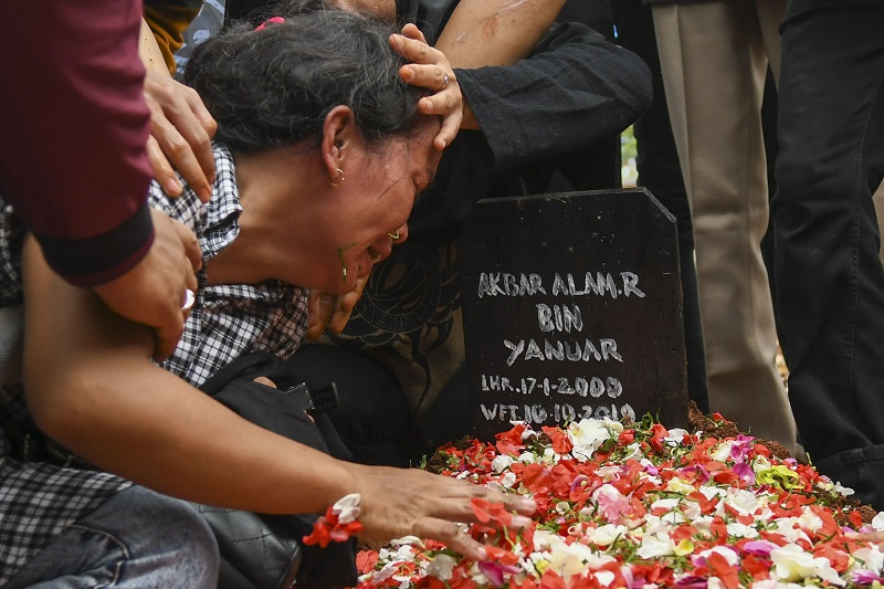 Ibu Akbar Alamsyah, Rosminah (kiri) menangis saat prosesi pemakaman korban demo ricuh Akbar Alamsyah di Taman Pemakaman Umum (TPU) kawasan Cipulir, Kebayoran Lama, Jakarta, Jumat (11/10). / Antara Foto