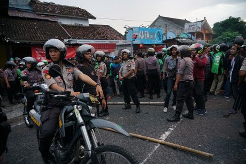 Polisi berjaga saat terjadi bentrok antara pengemudi ojek online (ojol) dengan debt collector di kawasan Babarsari, Sleman, DI Yogyakarta, Kamis (5/3). /Foto Antara