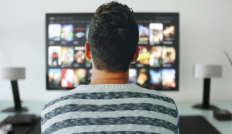Ilustrasi seorang pria tengah menonton layanan Netflix. Foto Pixabay.
